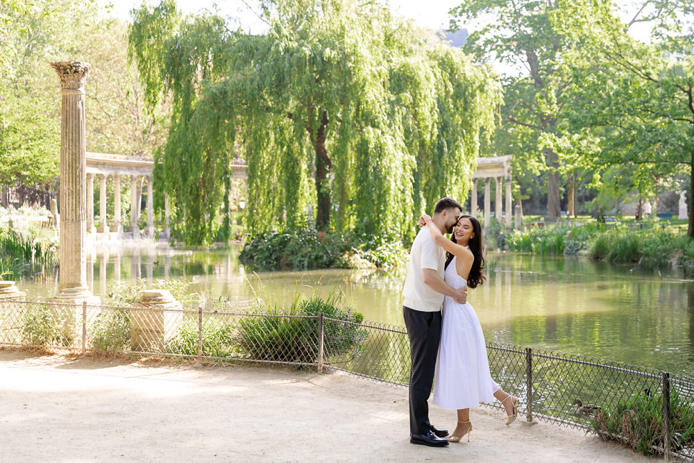 Couple embracing by the pond and colonnade of Parc Monceau in Paris, a calm garden setting captured by couples photographer Lena